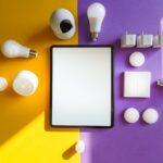 Top view of smart home devices and tablet on split yellow and purple background.