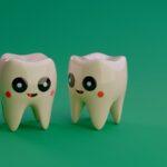 Two cartoon teeth smiling on a green background