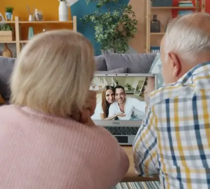 Elderly couple video calling with family at home.