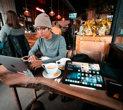 a man sitting at a table working on a laptop