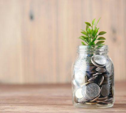 a glass jar filled with coins and a plant