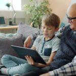 Grandfather and grandson looking at a tablet together.
