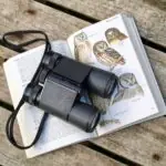 black binoculars on opened book