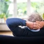 man lying on black couch