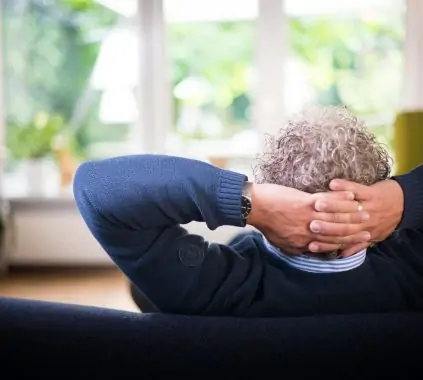 man lying on black couch