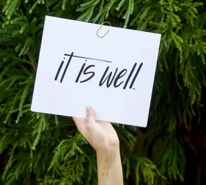 person holding white paper with it is well text