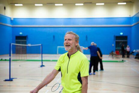 Man smiling in a badminton court